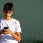 un adolescent qui regarde son smartphone